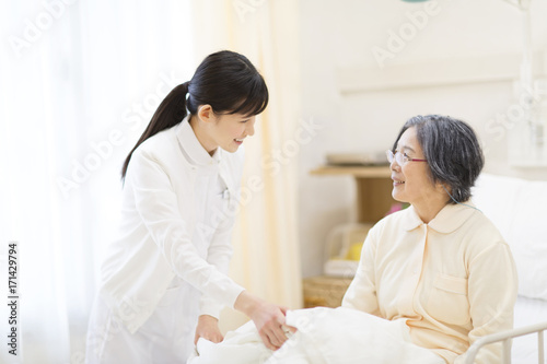 Nurse talking with patient in bed