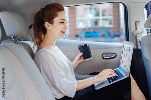 Cheerful attractive woman looking at the laptop screen