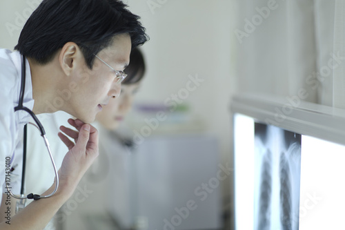 Male doctor and nurse looking at an X－ray