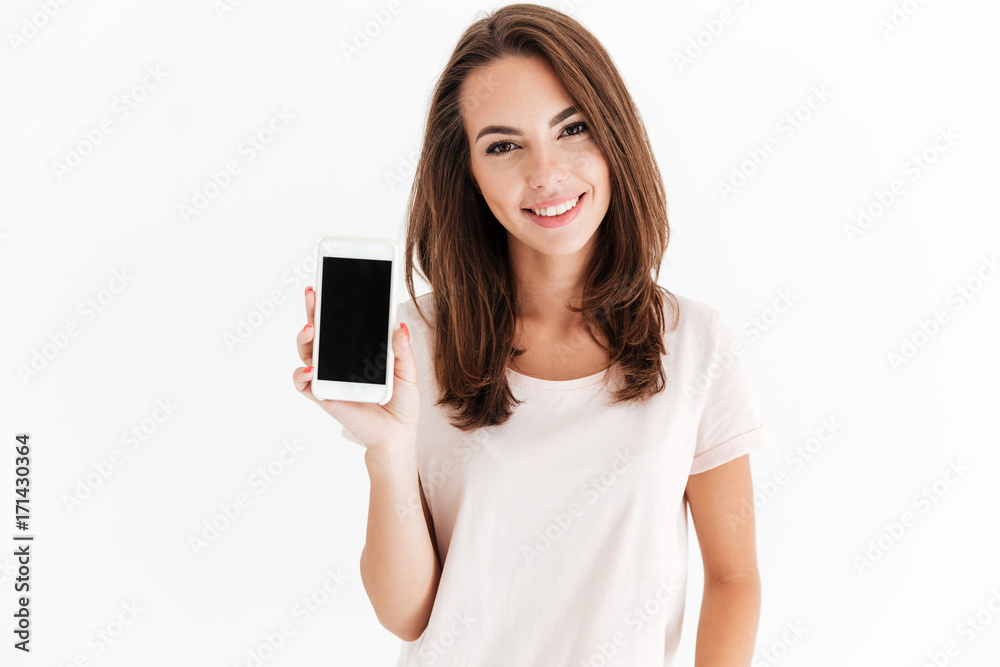 Joyful brunette woman showing blank smartphone screen - obrazy, fototapety, plakaty 