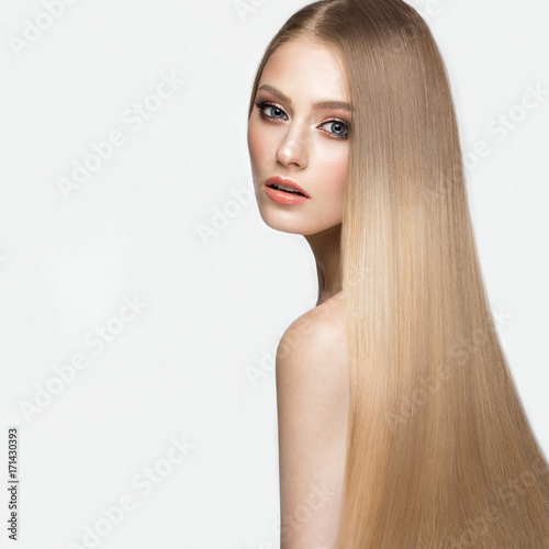 Beautiful blond girl with a perfectly smooth hair, and classic make-up. Beauty face. Picture taken in the studio.