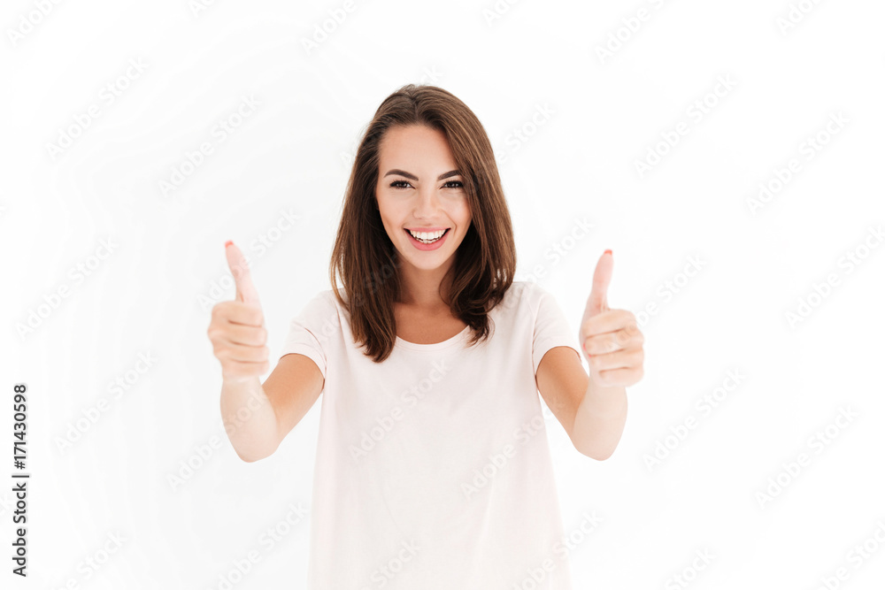 Smiling woman showing thumbs up and looking at the camera Smiling woman showing thumbs up and looking at the camera