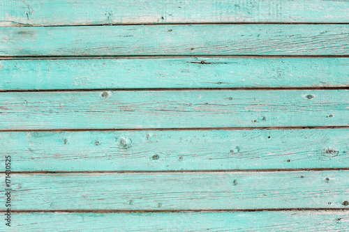 Wooden texture of turquoise color. Old painted fence of boards.
