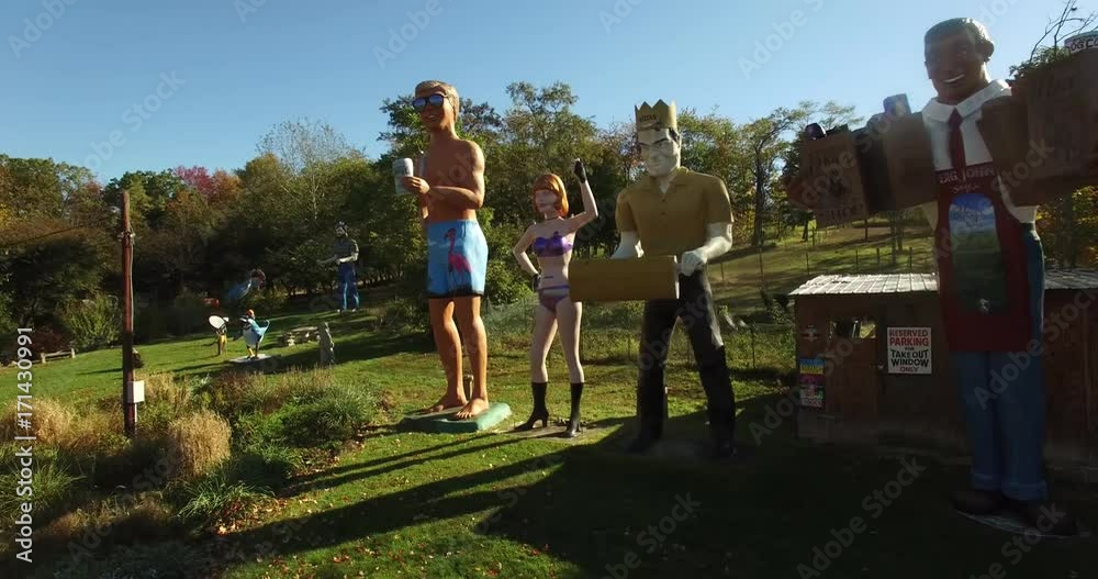 Backlit sunrise aerial views of an eccentric’s collection of giant American roadside attractions and oddities like Muffler Man, Brian Wilson the Beach Boy, Muffler Woman, and Grocery Man.  All set in 