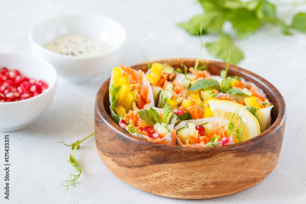 raw spring rolls with vegetables in a wooden bowl raw spring rolls with vegetables in a wooden bowl