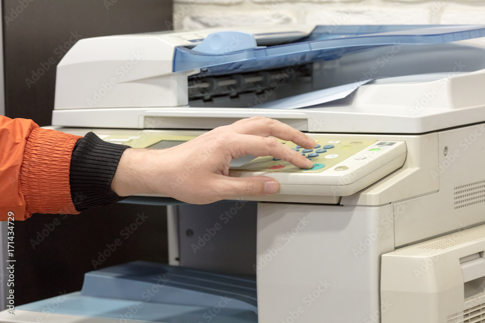 hand presses button in big printer hand presses button in big printer