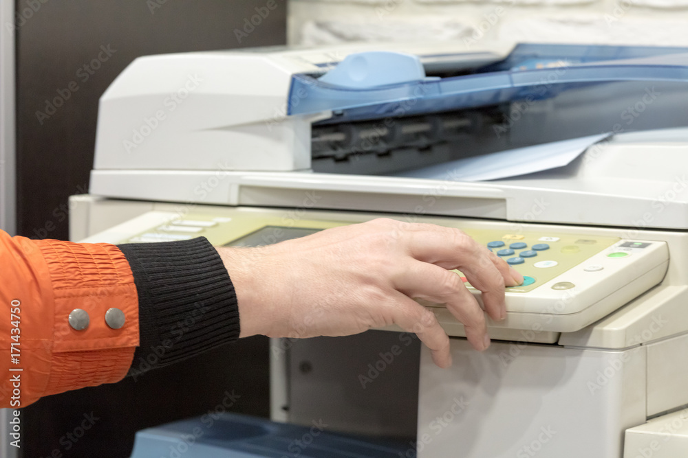 hand presses button in big multifunction printer hand presses button in big multifunction printer