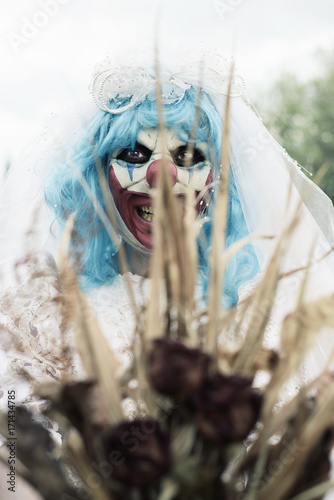 Fototapeta Naklejka Na Ścianę i Meble -  scary evil clown in a bride dress