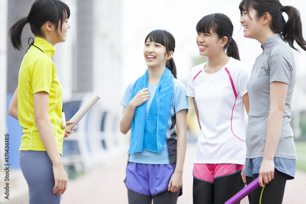 Female students talking on running track Female students talking on running track