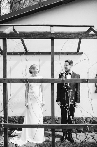 Beautiful sexy bride and handsome groom with beard and mustache separate. Newlyweds portrait