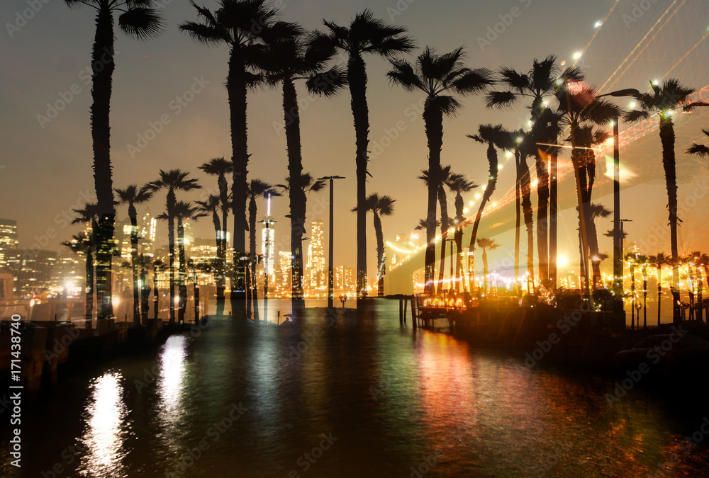 Double exposure palm trees with bridge and city building at night