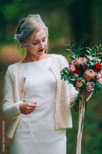 bride with flowers in hand outdoors.