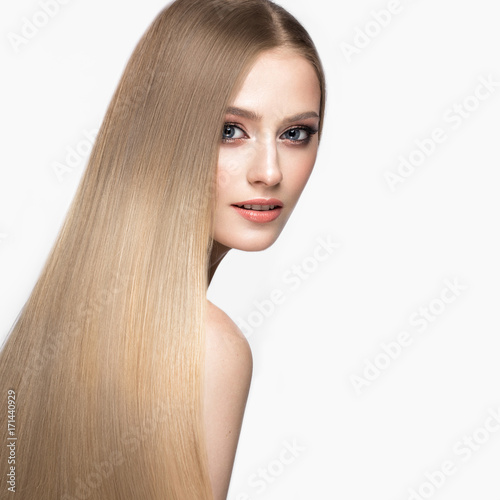 Beautiful blond girl with a perfectly smooth hair, and classic make-up. Beauty face. Picture taken in the studio.