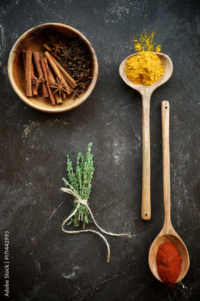 Variety of spices in bowls and spoons,bunch of thyme.Concept photo minimalism Variety of spices in bowls and spoons,bunch of thyme.Concept photo minimalism