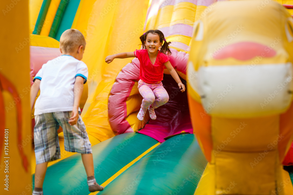 Fototapeta premium Joyful little girl playing on a trampoline.