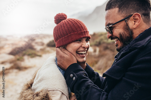 Smiling couple enjoying a winter day at the beach