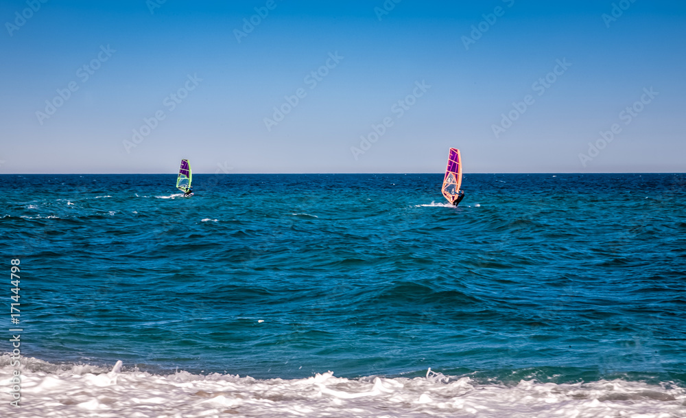 Wind surfers on the blue sea