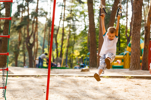 Photography little boy playing on monkey bars in autumn, kids sport