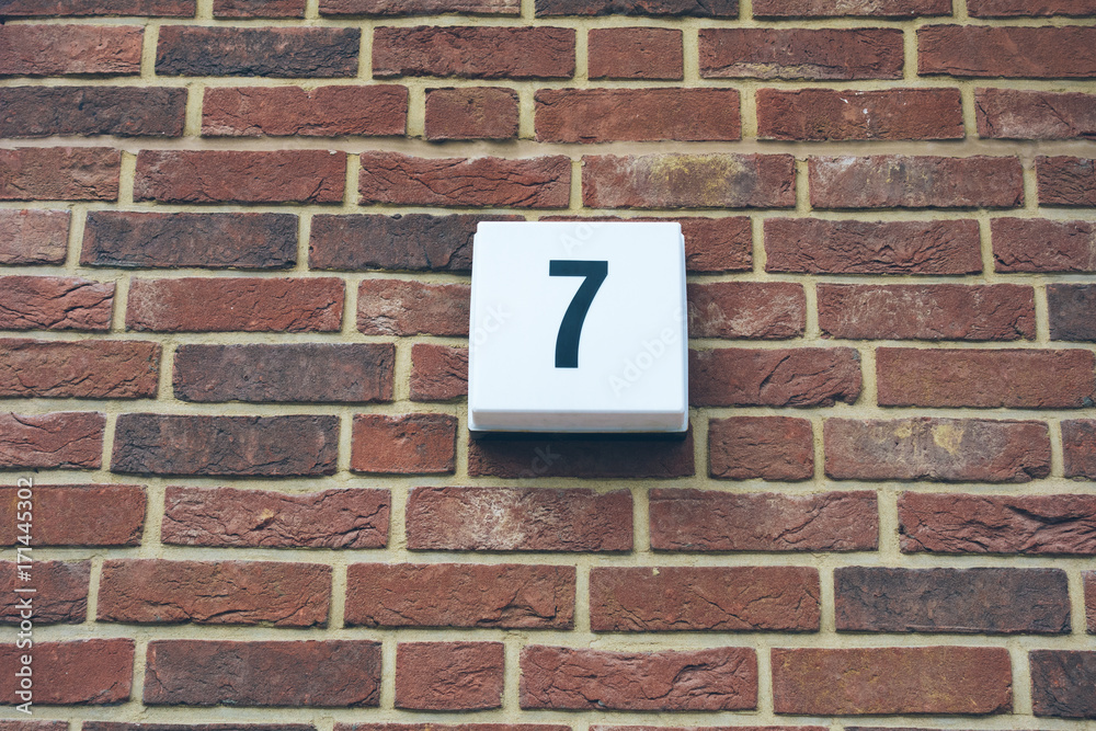 number seven door sign on brick facade number seven door sign on brick facade