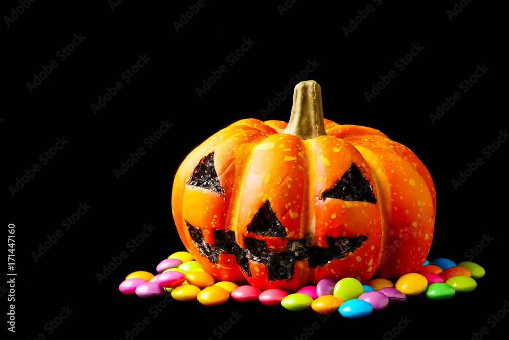 Halloween pumpkin with candies on a black background. Halloween pumpkin with candies on a black background.