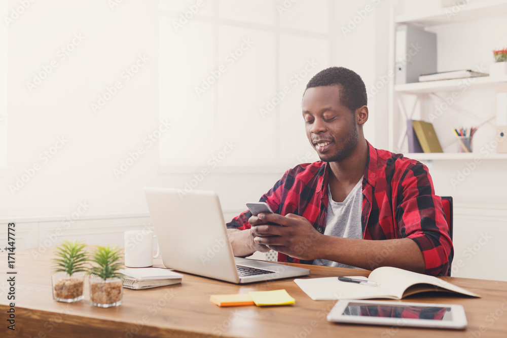 Young black businessman with mobile phone in modern white office Young black businessman with mobile phone in modern white office