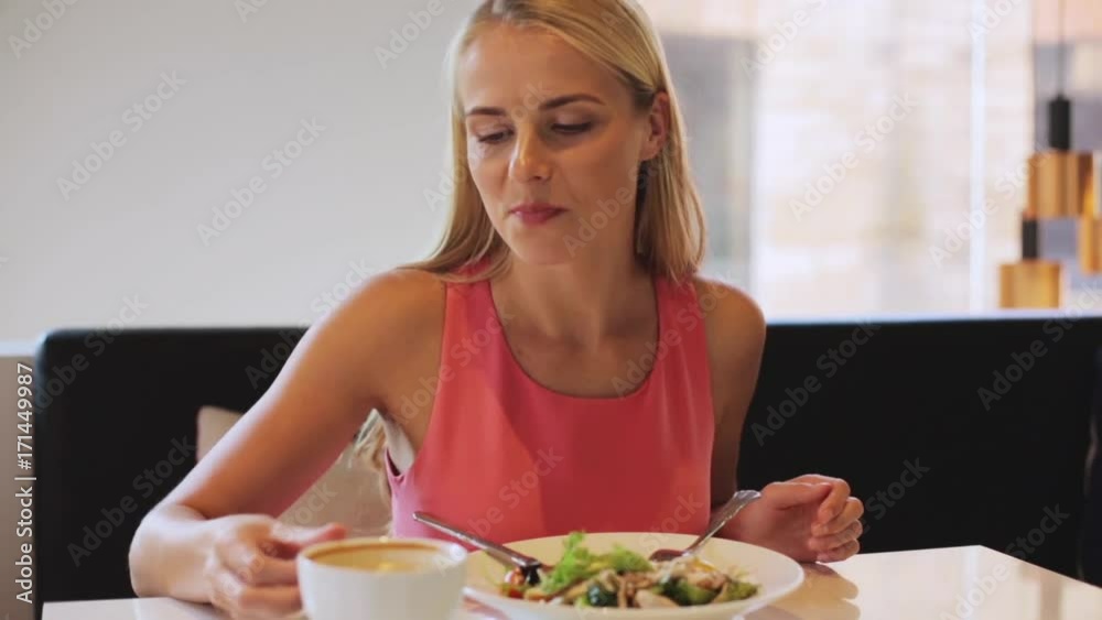 woman eating and drinking coffee at restaurant woman eating and drinking coffee at restaurant