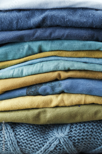 Pile of woolen jerseys on a wooden table
