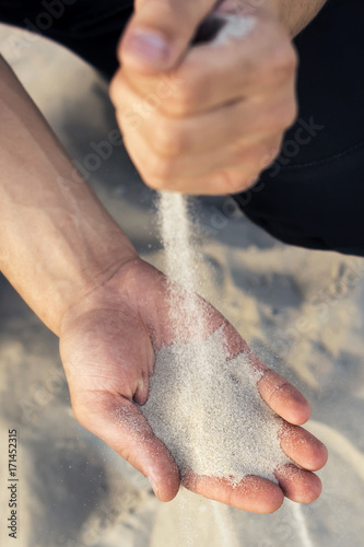 Sand flowing through your fingers. Hand with the sand.