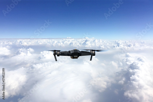 Fototapeta Naklejka Na Ścianę i Meble -  Drone with digital camera flying above clouds