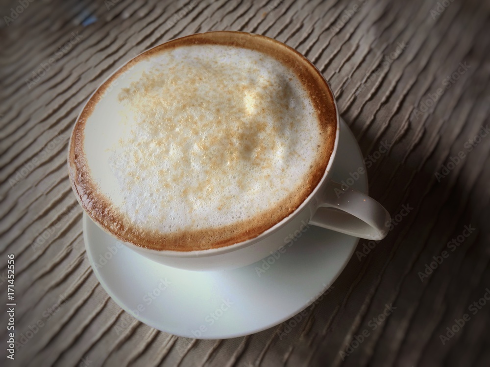 Close up white cappuccino cup on table in vintage tone Close up white cappuccino cup on table in vintage tone