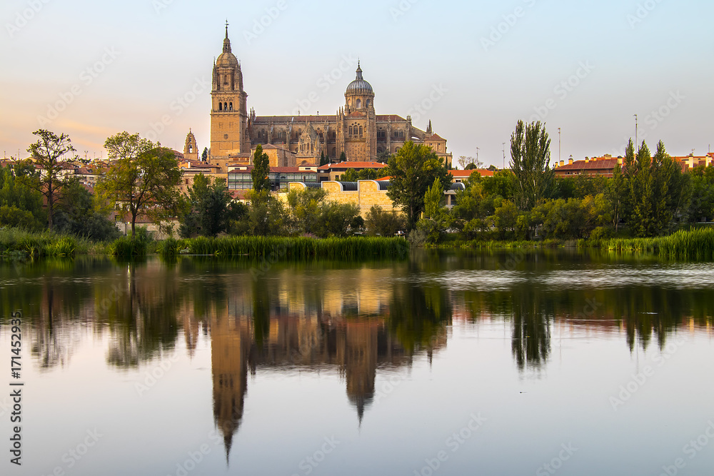 Salamanca Old and New Cathedrales reflected on Tormes River at sunset, Spain