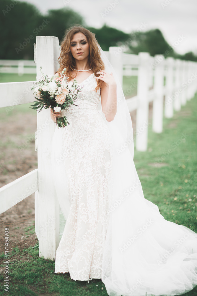 Portrait of stunning bride with long hair posing with great bouquet Portrait of stunning bride with long hair posing with great bouquet