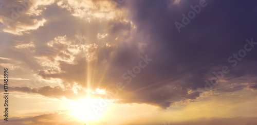 a bright sunset in the sky. the lights of a sun. blue and orange shades