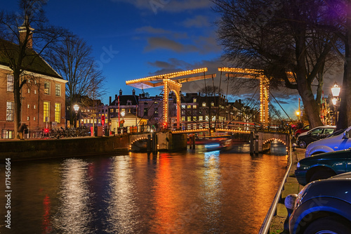 Illuminated bridge in the old town of Amsterdam in the evening