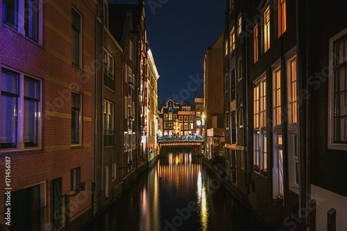 Narrow canal in the old town of Amsterdam in the evening