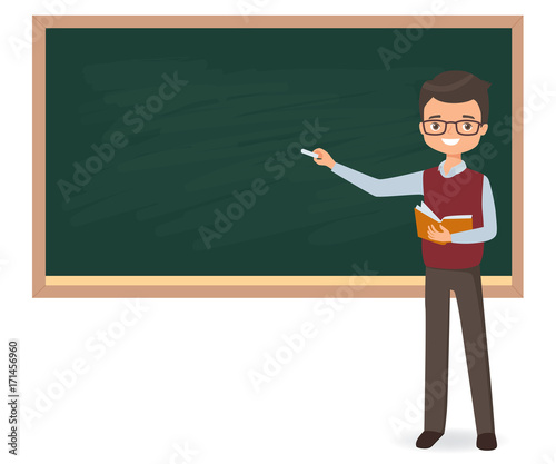 Young male teacher is writing chalk on a school blackboard