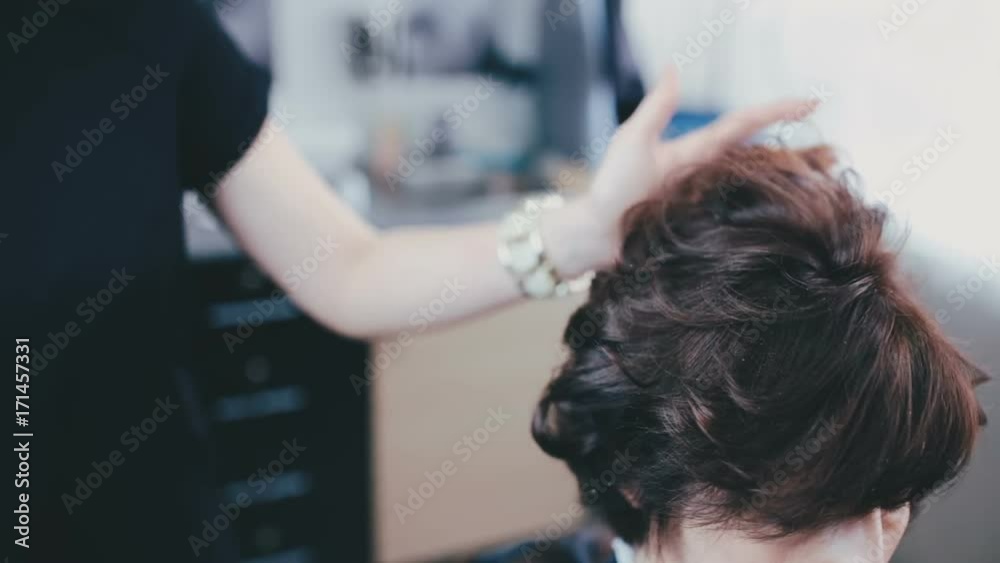 Hairdresser smooths hair to the client close up Hairdresser smooths hair to the client close up