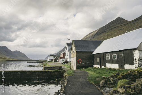 Houses by sea against cloudy sky photo