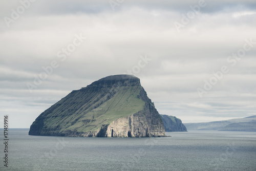 Idyllic view of island in sea against cloudy sky photo