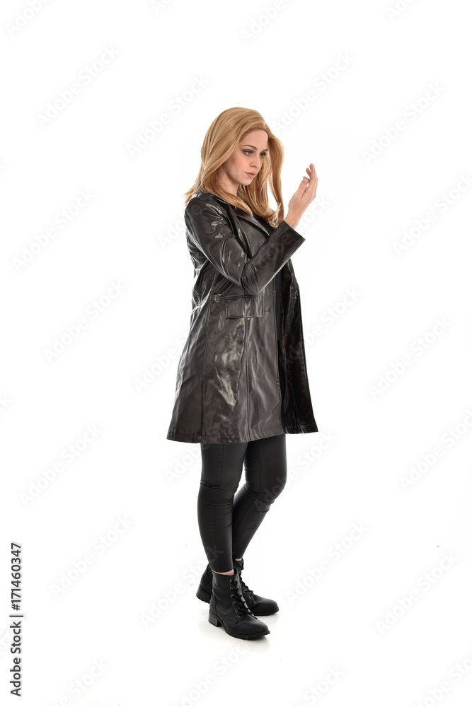 full length portrait of girl wearing black clothes with long leather jacket. standing pose on white background. full length portrait of girl wearing black clothes with long leather jacket. standing pose on white background.