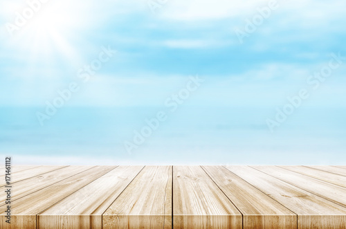 Empty wooden table top with blurred sea and sky background. Abstract background.