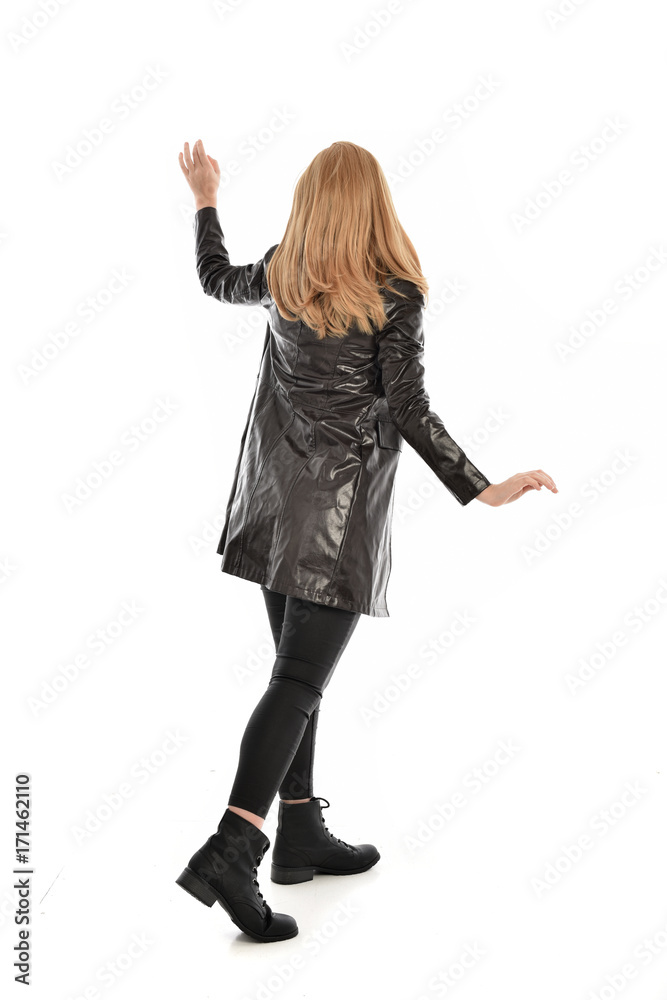 full length portrait of girl wearing black clothes with long leather jacket. standing pose on white background. full length portrait of girl wearing black clothes with long leather jacket. standing pose on white background.