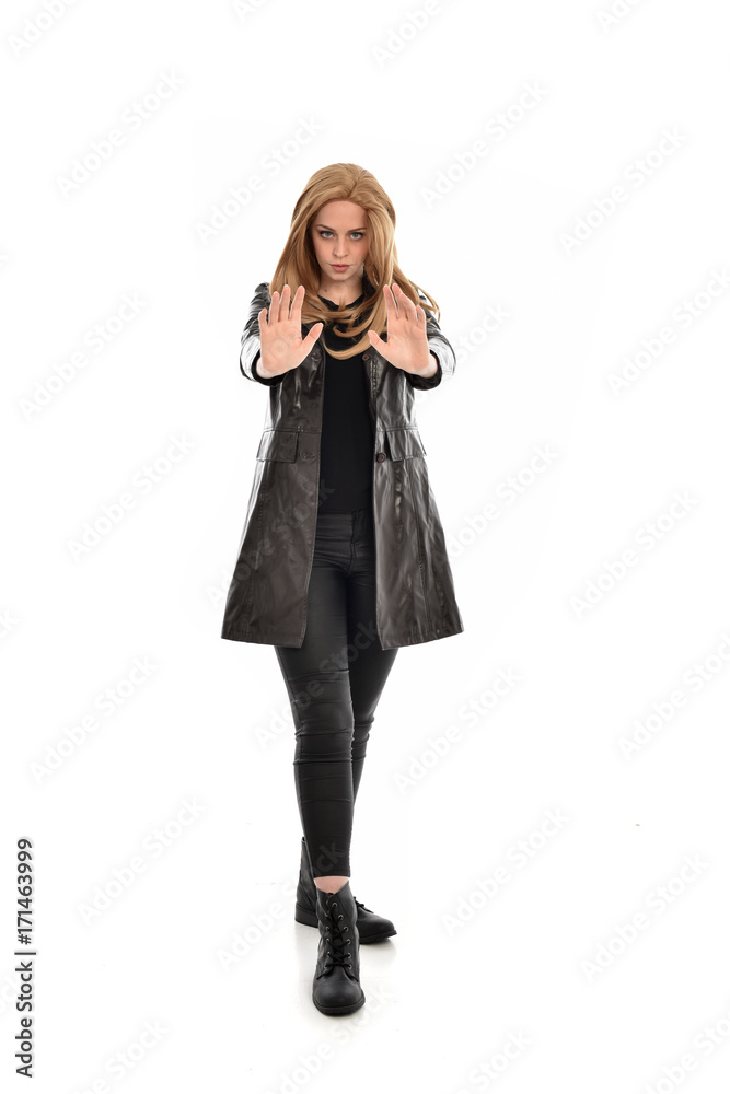 full length portrait of girl wearing black clothes with long leather jacket. standing pose on white background. full length portrait of girl wearing black clothes with long leather jacket. standing pose on white background.