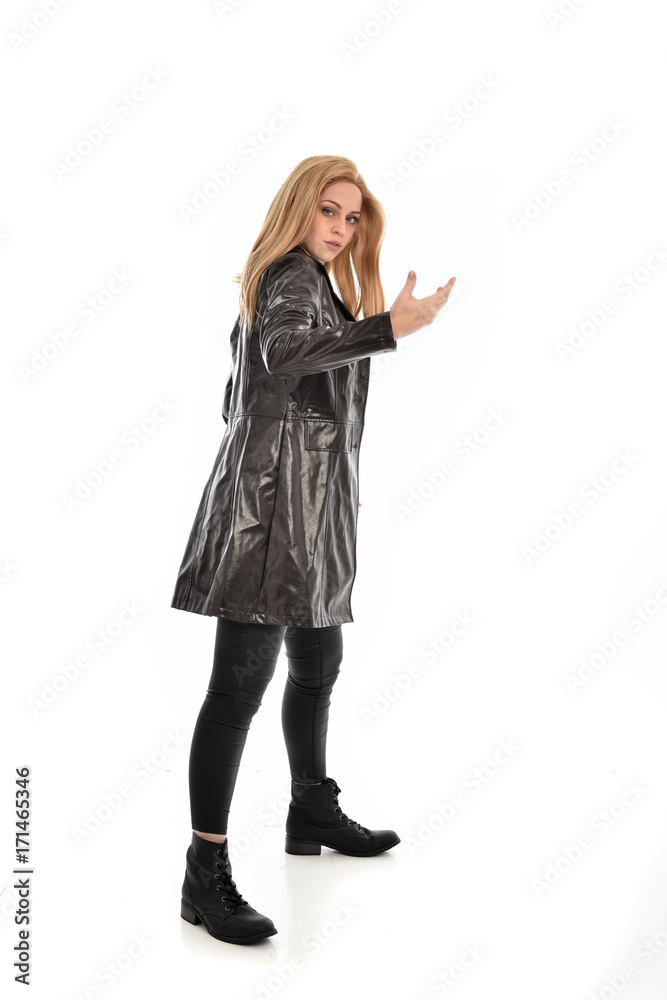 full length portrait of girl wearing black clothes with long leather jacket. standing pose on white background. full length portrait of girl wearing black clothes with long leather jacket. standing pose on white background.