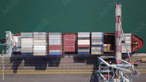 LARGE container ship fully loaded with containers and cargo - aerial 4k view top down
