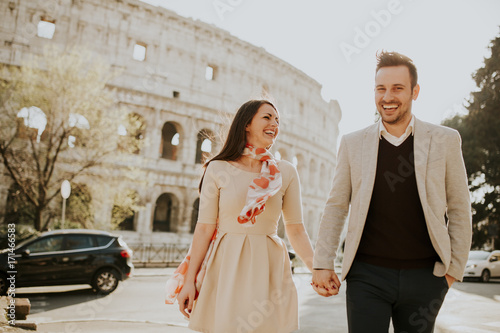 Leinwand Poster Loving couple visiting Italian famous landmarks Colosseum in Rome, Italy