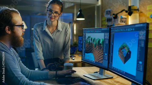 Male Game Developer Talks with Artistic Female Level Designer. Two Displays Show Totally Original Game. They Work in a Creative Office Loft.