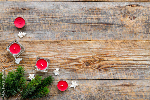 Christmas eve with spruce branches and candles on wooden background top veiw mock-up