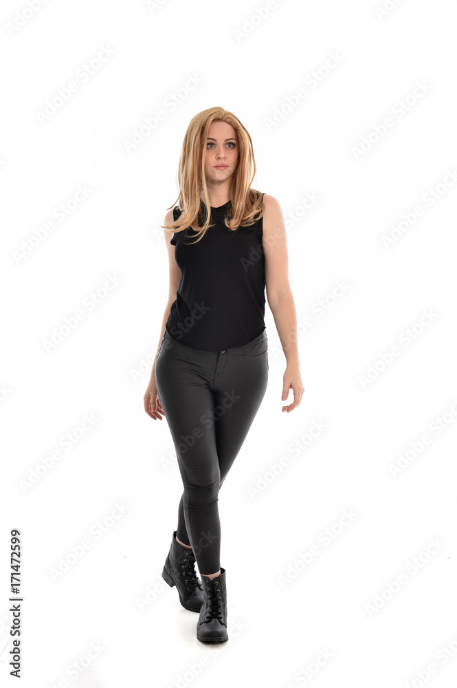 full length portrait of girl wearing black clothes and long leather jacket. standing pose in white background. full length portrait of girl wearing black clothes and long leather jacket. standing pose in white background.