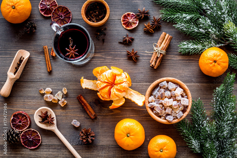 Hot mulled wine or grog cooking for new year celebration with oranges and spices ingredients on wooden background flat lay Hot mulled wine or grog cooking for new year celebration with oranges and spices ingredients on wooden background flat lay